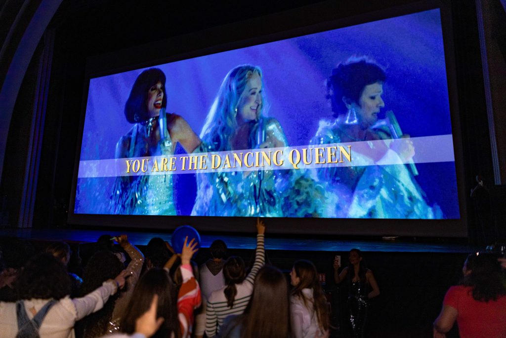 Le public chante "You Are the Dancing Queen" lors d'une séance de Cinéma Karaoké Mamma Mia à L'Ecran Pop